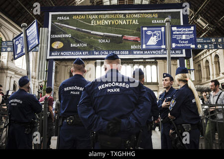 La polizia ungherese monitor come siro rifugiati e migranti a bordo di un treno in direzione di Vienna nella stazione ferroviaria Keleti a Budapest, in Ungheria il 6 settembre 2015. Foto di Achilleas Zavallis/UPI Foto Stock