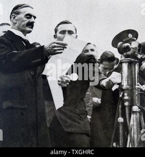 Stampa fotografica di Primo Ministro Neville Chamberlain (1869-1940) la lettura del suo e di Adolf Hitler risoluzione congiunta "mai di andare in guerra con un altro ancora". Datata 1938 Foto Stock