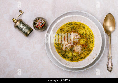 Una deliziosa zuppa di pollo o tacchino polpette di carne con verdure - patate, carote, aneto, prezzemolo e spezie in una piastra bianca. Messa a fuoco selettiva, top v Foto Stock
