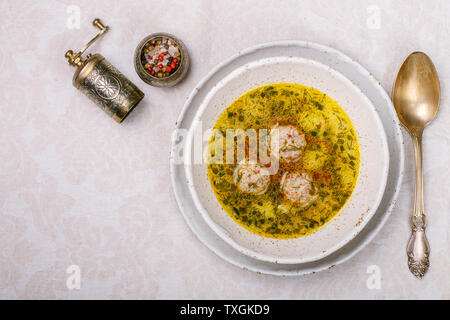 Una deliziosa zuppa di pollo o tacchino polpette di carne con verdure - patate, carote, aneto, prezzemolo e spezie in una piastra bianca. Messa a fuoco selettiva, top v Foto Stock