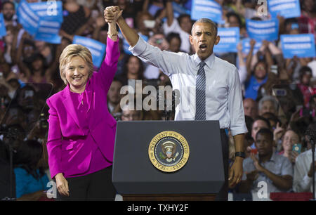 Il presidente Barack Obama e il candidato presidenziale democratico Hillary Clinton tenere le mani dopo aver premuto un evento di campagna a Charlotte, Carolina del Nord il 5 luglio 2016. Questo è il primo evento che il Presidente Obama ha lottato con Clinton. Foto di Kevin Dietsch/UPI Foto Stock