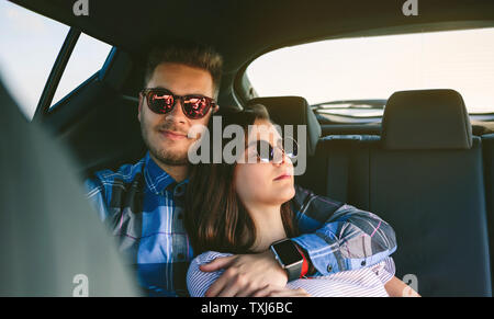 Coppia giovane in appoggio sul sedile posteriore della vettura Foto Stock