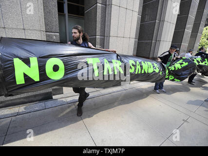 I manifestanti di dimostrare al di fuori del Consolato canadese contro l'Athabasca oil sands produzione e la pipeline di Keystone, 17 maggio 2012 a Chicago. La protesta si è svolta come parte del giro le dimostrazioni che conduce fino al vertice della NATO che si terrà il 20 maggio e 21 maggio a Chicago. UPI/Brian Kersey Foto Stock