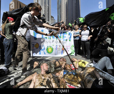 Manifestanti coprirsi in olio simulato al di fuori del Consolato canadese durante una manifestazione contro l'Athabasca oil sands produzione e la pipeline di Keystone, 17 maggio 2012 a Chicago. La protesta si è svolta come parte del giro le dimostrazioni che conduce fino al vertice della NATO che si terrà il 20 maggio e 21 maggio a Chicago. UPI/Brian Kersey Foto Stock