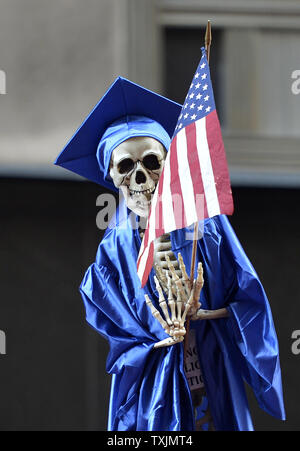 Membri del Chicago insegnanti Unione e i loro sostenitori tenere premuto su uno scheletro vestito in costume di graduazione come essi marzo nella parte anteriore del Chicago Public Schools sede il 10 settembre 2012 a Chicago. Chicago's 25.000 insegnanti sono in sciopero da lunedì per la prima volta in venticinque anni dopo le ultime trattative contrattuali si è rotta la domenica notte con nessuna trattativa per scongiurare una walkout. UPI/Brian Kersey Foto Stock