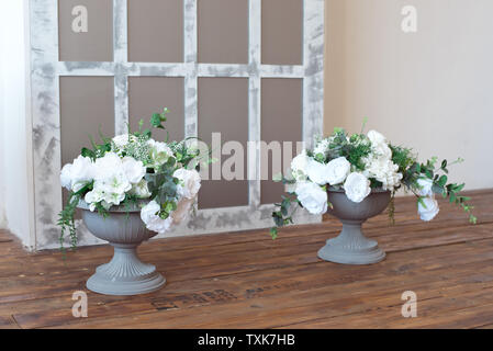 Bianco antico urna italiano piantatrice con fiori di colore bianco in stile barocco camera Foto Stock