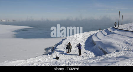 La gente a prendere le foto come vapore sorge dal lago Michigan a Chicago il 31 gennaio 2019. Il vortice polare sta portando anormalmente basse temperature per il Midwest degli Stati Uniti. . Foto di Blake Clark/UPI Foto Stock