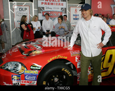 Attore Owen Wilson (Lightning McQueen) pause nella parte anteriore di una gara NASCAR auto sul tappeto rosso al mondo premiere mostra della Disney-Pixar film 'Auto' al Lowe's Motor Speedway di Charlotte, NC, il 26 maggio 2006. Il film è stato mostrato su quattro schermi esterni all'interno del speedway. (UPI foto/Bob Carey) Foto Stock