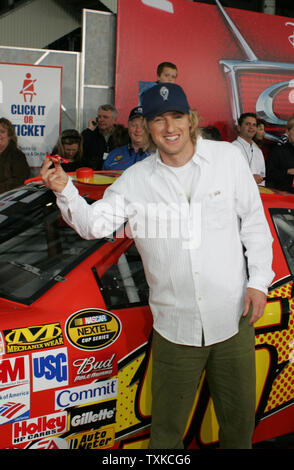 Attore Owen Wilson (Lightning McQueen) mette in mostra la sua vettura da gara davanti a una gara NASCAR auto sul tappeto rosso al mondo premiere mostra della Disney-Pixar film 'Auto' al Lowe's Motor Speedway di Charlotte, NC, il 26 maggio 2006. Il film è stato mostrato su quattro schermi esterni all'interno del speedway. (UPI foto/Bob Carey) Foto Stock