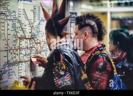 Punks controllo mappa tubo nella metropolitana di Londra, Inghilterra, Regno Unito. Foto Stock