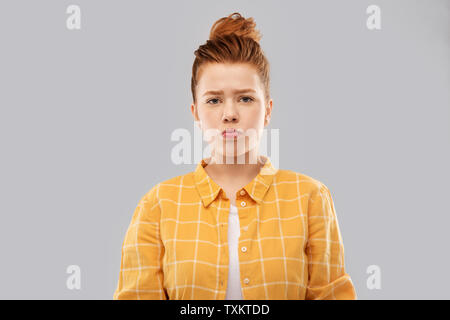 Triste dai capelli rossi ragazza adolescente in camicia Busbana francese Foto Stock