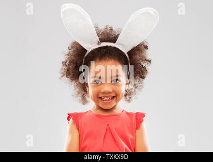 Felice bambina indossa coniglietto pasquale per le orecchie Foto Stock