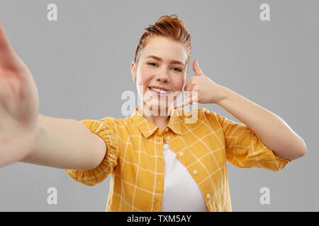 Ragazza adolescente tenendo selfie compiendo il gesto di chiamata Foto Stock