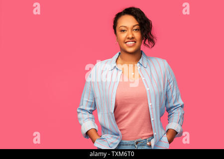 Felice americano africano donna su sfondo rosa Foto Stock