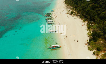 Costa con spiaggia sabbiosa con turisti e limpido mare blu top view, Puka shell beach. Il Boracay, Filippine. Seascape con spiaggia sull isola tropicale. Estate viaggi e concetto di vacanza. Foto Stock