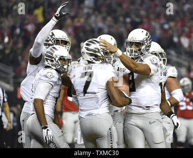 Oregon Ducks Keanon Lowe festeggia con i compagni di squadra dopo egli i punteggi su un 7 yard touchdown ricevimento nel primo trimestre contro la Ohio State Buckeyes presso il College Football Playoff Campionato Nazionale di Arlington, Texas, il 12 gennaio 2015. Foto di Kevin Dietsch/UPI Foto Stock