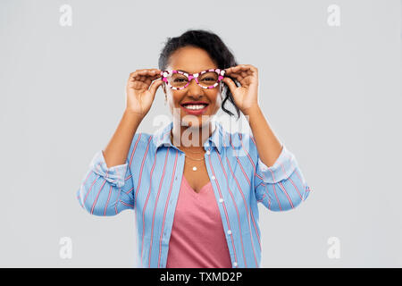 Felice americano africano donna con bicchieri di grandi dimensioni Foto Stock