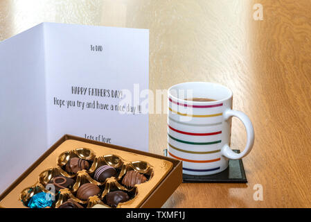 Padri giorno della carta sul tavolo di legno con una scatola di cioccolatini e una tazza di caffè o tè. Foto Stock