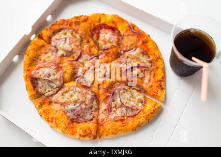 Ravvicinata di una pizza da asporto in scatola con tazza di cola Foto Stock