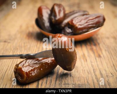 Organici dolci di datteri secchi su una tavola in legno rustico Foto Stock