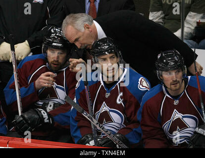 Colorado Avalanche head coach Joel Quenneville (top) si appoggia per parlare con Peter Forsberg (L) che è venuto solo fuori dal ghiaccio dopo il suo primo turno contro il Vancouver Canucks durante il primo periodo presso il Pepsi Center di Denver il 4 marzo 2008. Forsberg ha svolto il suo primo gioco fin dalla firma con la valanga come un unrestricted free agent. Avalanche Joe Sakic (C) e Milano Hejduk sedersi accanto a Forsberg. (UPI foto/Gary C. Caskey) Foto Stock