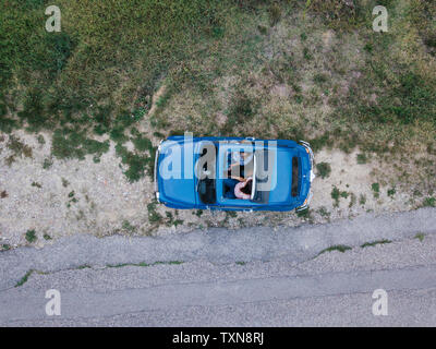 Overhead view of friends talking inside car by roadside Foto Stock