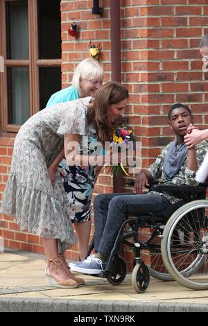 La Duchessa di Cambridge riceve fiori da Lemar (nessun cognome dato) come lei lascia Warren Park Centro per l'infanzia, Kingston upon Thames, dopo aver preso parte a un Royal Photographic Society workshop con azione per i bambini che utilizzano la fotografia per aiutare i giovani a sviluppare la fiducia e l'espressione di sé. Foto Stock