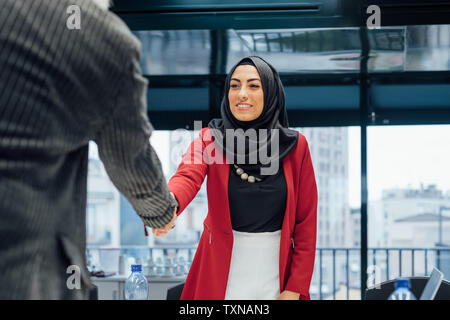 Business Partner agitando mani alla riunione in ufficio Foto Stock