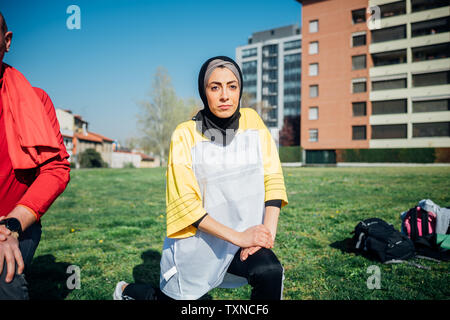 Classe Calisthenics presso palestra all'aperto, giovane donna e uomo guerriero pratica posizione di yoga Foto Stock
