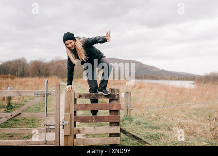 Trekker che si arrampica sul recinto da Loch Lomond, Trossachs National Park, Canada Foto Stock