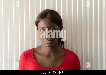 Giovane donna in rosso tshirt, la testa e la spalla verticale Foto Stock