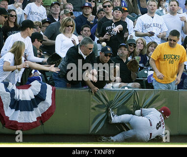 Un ventilatore cerca di catturare un Colorado Rockies Todd Helton fallo con la sfera verso il basso il campo sinistro linea con Arizona Diamondsback sinistra fielder Gerardo Parra di scorrimento per tentare una cattura a Coors Field sul giorno di apertura a Denver il 1 aprile 2011. Helton era escluso dalla terza base arbitro Bill Welke con un apparente ventola chiamata interferenza. UPI/Gary Caskey C. Foto Stock