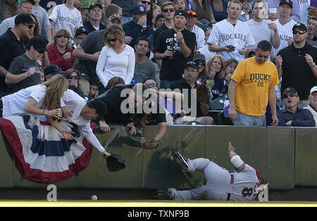 Un ventilatore cerca di catturare un Colorado Rockies Todd Helton fallo con la sfera verso il basso il campo sinistro linea con Arizona Diamondsback sinistra fielder Gerardo Parra di scorrimento per tentare una cattura a Coors Field sul giorno di apertura a Denver il 1 aprile 2011. Helton era escluso dalla terza base arbitro Bill Welke con un apparente ventola chiamata interferenza. UPI/Gary Caskey C. Foto Stock