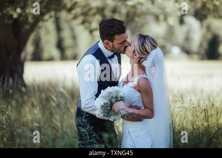 Romantico sposa e lo sposo baciare nel bosco Foto Stock