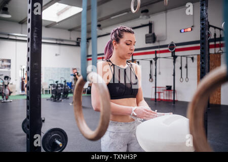 Giovane donna la polverizzazione di palme in palestra Foto Stock