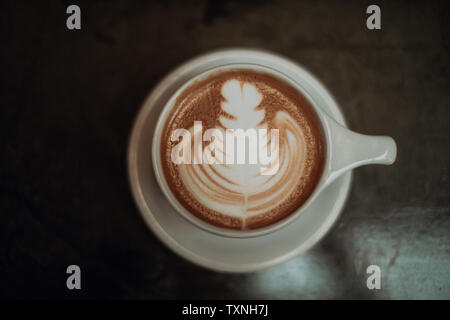 Tazza di moka e rabboccato con pattern sul tavolo del bar, chiave di basso vista aerea Foto Stock