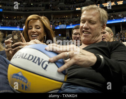 Denver Broncos Hall of Fame quarterback corrente e executive vice-presidente John Elway segni a Denver Nuggets autografo palla per la squadra mascotte, rocciosa, presso il Pepsi Center su dicembre 26, 2012 a Denver. Le Pepite fermato i Lakers winning streak con una vittoria 126-114. UPI/Gary Caskey C. Foto Stock