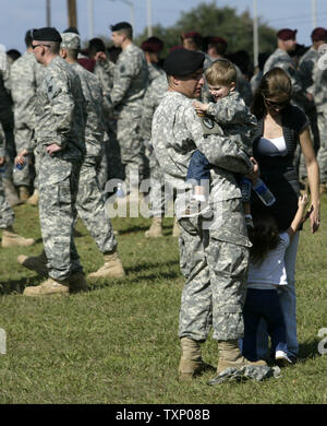 Army Spc. Ryan Dickinson, 22, di New York, trascorre un momento con la sua famiglia durante il Fort Hood memorial al III Corps sede in Killeen, Texas, il 10 novembre 2009. Parlando la settimana scorsa il tiri su base Dickinson detto "non puoi davvero puntare le dita - è accaduto e che hai appena ottenuto di spostare su". Dickinson la moglie, Erica, estrema destra, detiene la loro figlia Neaeah, mentre egli detiene il loro figlio, Luca. UPI/Robert Hughes) Foto Stock