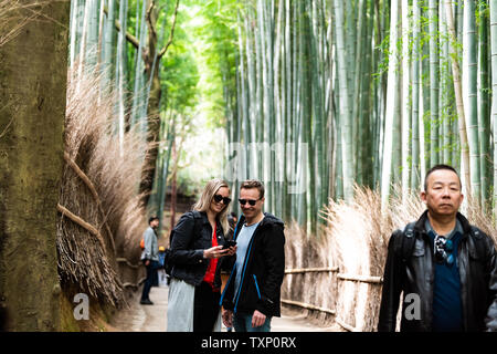 Kyoto, Giappone - 11 Aprile 2019: Arashiyama foresta di bamboo park durante il giorno con un paio di persone contente e turisti sul percorso Foto Stock