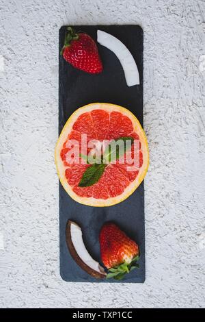 Lay piatto con sfondo bianco con frutti tropicali e fiori Foto Stock