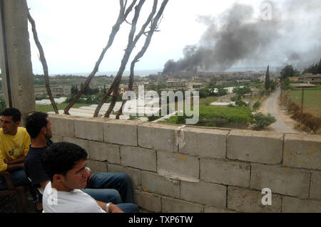 Residenza libanese guardare come un pennacchio di fumo si alza dal centro di Nahr al-Bared campo profughi palestinese, nei pressi di Tripoli, il 2 giugno 2007. Militare libanese continua a bombardare le posizioni detenute da islamica del gruppo di militanti del Fatah al-Islam. (UPI foto/Nicholas Blanford) Foto Stock