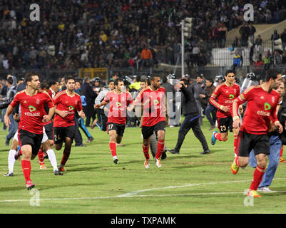 I fan della squadra Al-Masry eseguire dopo che i giocatori della squadra Al-Ahly durante disordini che sono scoppiati dopo la partita di calcio tra i due team di Port Said, 220 km a nord-est del Cairo, il 1 febbraio 2012. Almeno 73 persone sono state uccise e centinaia di feriti in violenza scoppiata non appena l'arbitro soffiò il fischio finale nella partita. UPI/Ahmed Gomaa Foto Stock