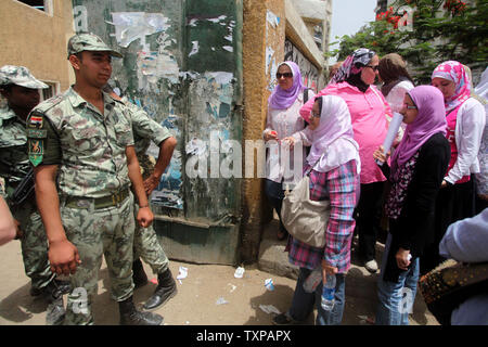 Un egiziano soldati dell esercito sta di guardia all'interno di una stazione di polling come donne di attendere per il loro voto nel paese di elezione presidenziale, al Cairo in Egitto. Il 23 maggio 2012. Gli egiziani sono andati a votare il mercoledì mattina per eleggere un nuovo presidente dopo la caduta dell ex-Presidente Hosni Mubarak lo scorso anno. UPI/Ashraf Mohamad Foto Stock