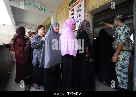 Un egiziano soldati dell esercito sta di guardia all'interno di una stazione di polling come donne di attendere per il loro voto nel paese di elezione presidenziale in, Zakazik 80 chilometri (50 miglia) a nord del Cairo, Egitto, mercoledì 23 maggio, 2012. Gli egiziani sono andati a votare il mercoledì mattina per eleggere un nuovo presidente dopo la caduta dell ex-Presidente Hosni Mubarak lo scorso anno. UPI/Ahmed Jomaa Foto Stock