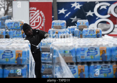 Un volontario non imballato casi di acqua in bottiglia per distribuire ai residenti colpiti dalla crisi idrica di Flint, Michigan, 5 marzo 2016. La selce residenti continuano a usare acqua in bottiglia dopo l'acqua potabile è stata trovata essere contaminato con piombo dopo la fonte di acqua è stato commutato da Detroit acqua e la rete fognaria Dipartimento per il fiume Flint in aprile, 2014. Foto di Molly Riley/UPI Foto Stock