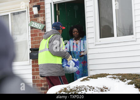 Un volontario che eroga acqua in bottiglia per i residenti colpiti dalla crisi idrica nella Evergreen Regency Apartments di Flint, Michigan, 5 marzo 2016. La selce residenti continuano a usare acqua in bottiglia dopo l'acqua potabile è stata trovata essere contaminato con piombo dopo la fonte di acqua è stato commutato da Detroit acqua e la rete fognaria Dipartimento per il fiume Flint in aprile, 2014. Foto di Molly Riley/UPI Foto Stock