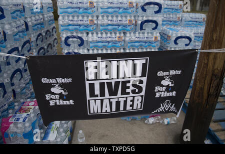 Volontari distribuiscono casi di acqua presso il municipio di Flint, Michigan, 12 marzo 2016. La selce residenti continuano a usare acqua in bottiglia dopo l'acqua potabile è stata trovata essere contaminato con piombo dopo la fonte di acqua è stato commutato da Detroit acqua e la rete fognaria Dipartimento per il fiume Flint in aprile, 2014. Foto di Molly Riley/UPI Foto Stock