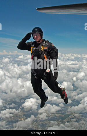 Un membro dell'Esercito USA 'Cavalieri d'Oro" saluta come egli esce il C-31A "Amicizia" nei cieli di Ft. Lauderdale come parte del McDonalds aria e mare mostra il 2 maggio 2004 in Ft Lauderdale, Florida. (UPI Foto Marino / Cantrell) Foto Stock