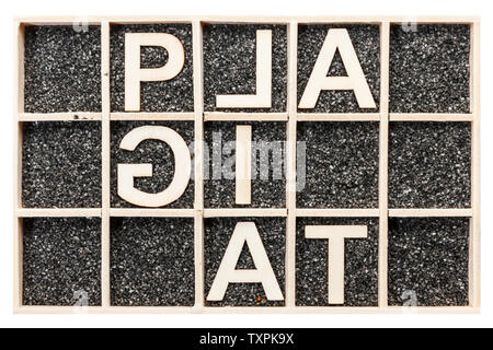 In modo univoco e parzialmente disposti speculari lettere di legno compensato sul nero Sabbia decorativa che rappresentano le parole PLAGIAT in vista dall'alto isolato su bianco backgro Foto Stock