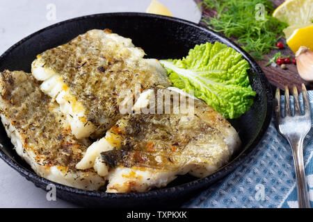 Merluzzo fritto di filetto con spice in una ghisa pan Foto Stock